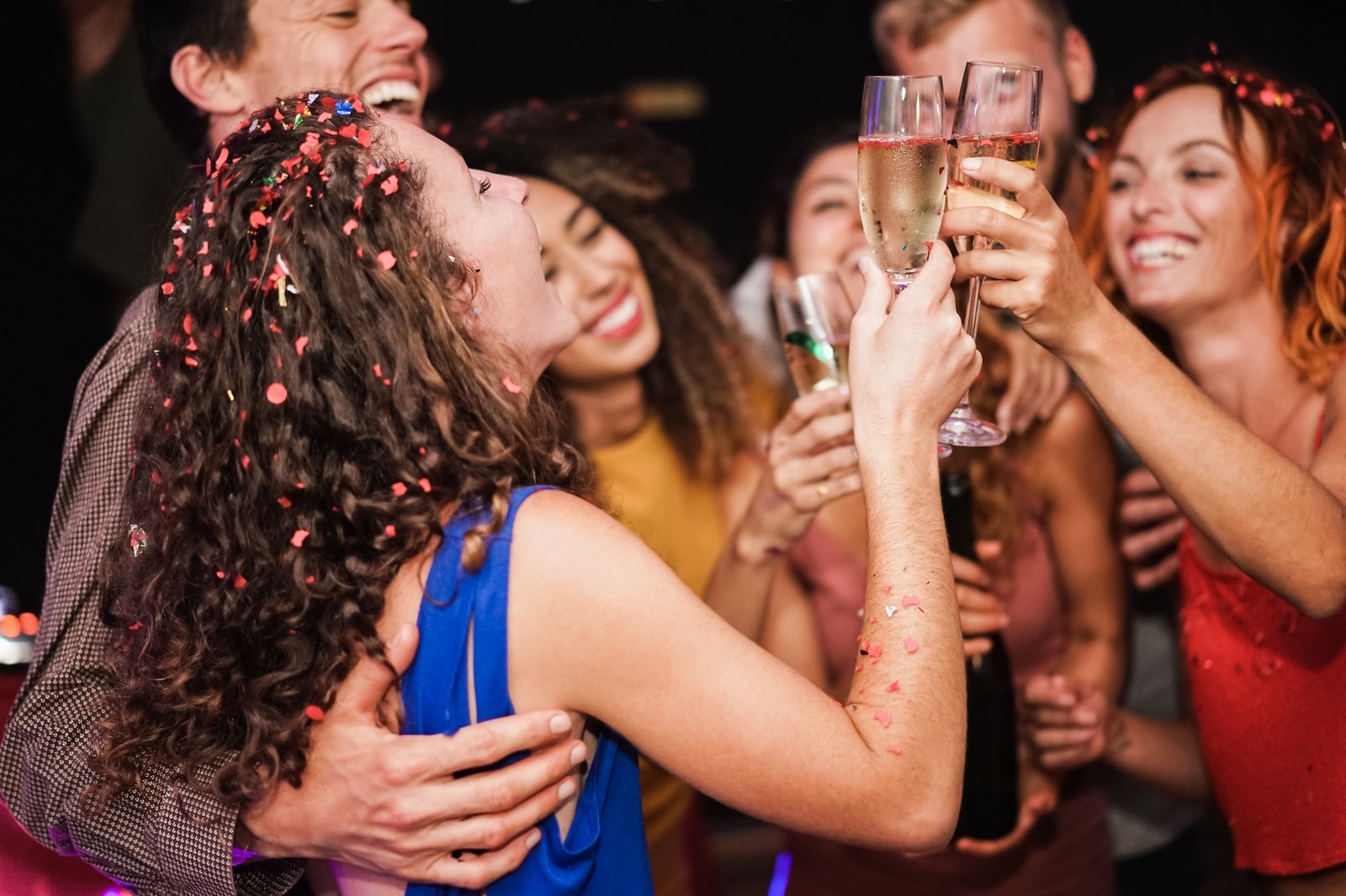 Group of happy friends cheering with champagne at private party